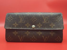 Louis Vuitton Wallet. Measuring 18.5cm wide, this Louis Vuitton wallet is patterned in the trademark