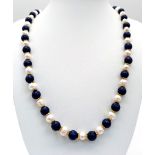 A Cultured Pearl and Lapis Lazuli Matinee Length Necklace. 8mm lapis and pearls. Gilded spacers