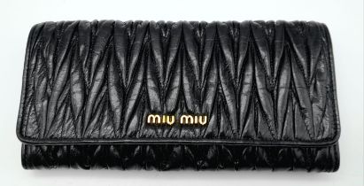 A Miu Miu Black Matelassé Leather Purse/Wallet. Gold logo on the front flap with two press stud