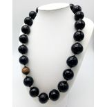 A Huge Black Onyx Bead Necklace with a Solitary Tigers Eye Interrupter. 20mm beads. 48cm necklace