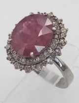 A 6.10ct Ruby Ring with Diamond Surround on 925 Silver. Size L 1/2, 6.24g total weight. Comes with