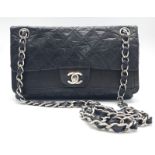A Chanel Black Crossbody Bag. Quilted leather exterior, with the iconic CC logo on the front flap.