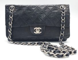 A Chanel Black Crossbody Bag. Quilted leather exterior, with the iconic CC logo on the front flap.