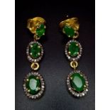 An Edwardian pair of silver and gold earrings with emeralds and old cut diamonds presented in a