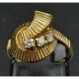 A 9K Yellow Gold Diamond Trilogy Twist Ring. Three round cut diamonds amongst a swirl of gold.