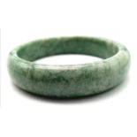 A Chinese Green Jade Bangle. 58cm inner diameter. 15mm width.