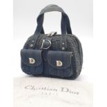 A Christian Dior Denim Handbag. Woven denim exterior with two exterior pockets. Silver-toned metal
