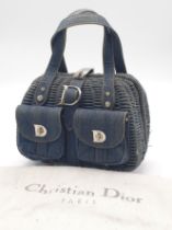 A Christian Dior Denim Handbag. Woven denim exterior with two exterior pockets. Silver-toned metal