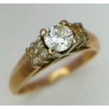 A 14K Yellow Gold Diamond Ring. Brilliant cut central diamond with four small stones either side.