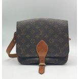 A Louis Vuitton Monogram Cartouchiere Crossbody Bag. Pebbled leather exterior. Adjustable front flap
