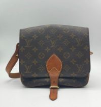 A Louis Vuitton Monogram Cartouchiere Crossbody Bag. Pebbled leather exterior. Adjustable front flap