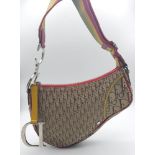 A Christian Dior Rasta Saddle Shoulder Bag. Tan and brown monogram canvas with red piping