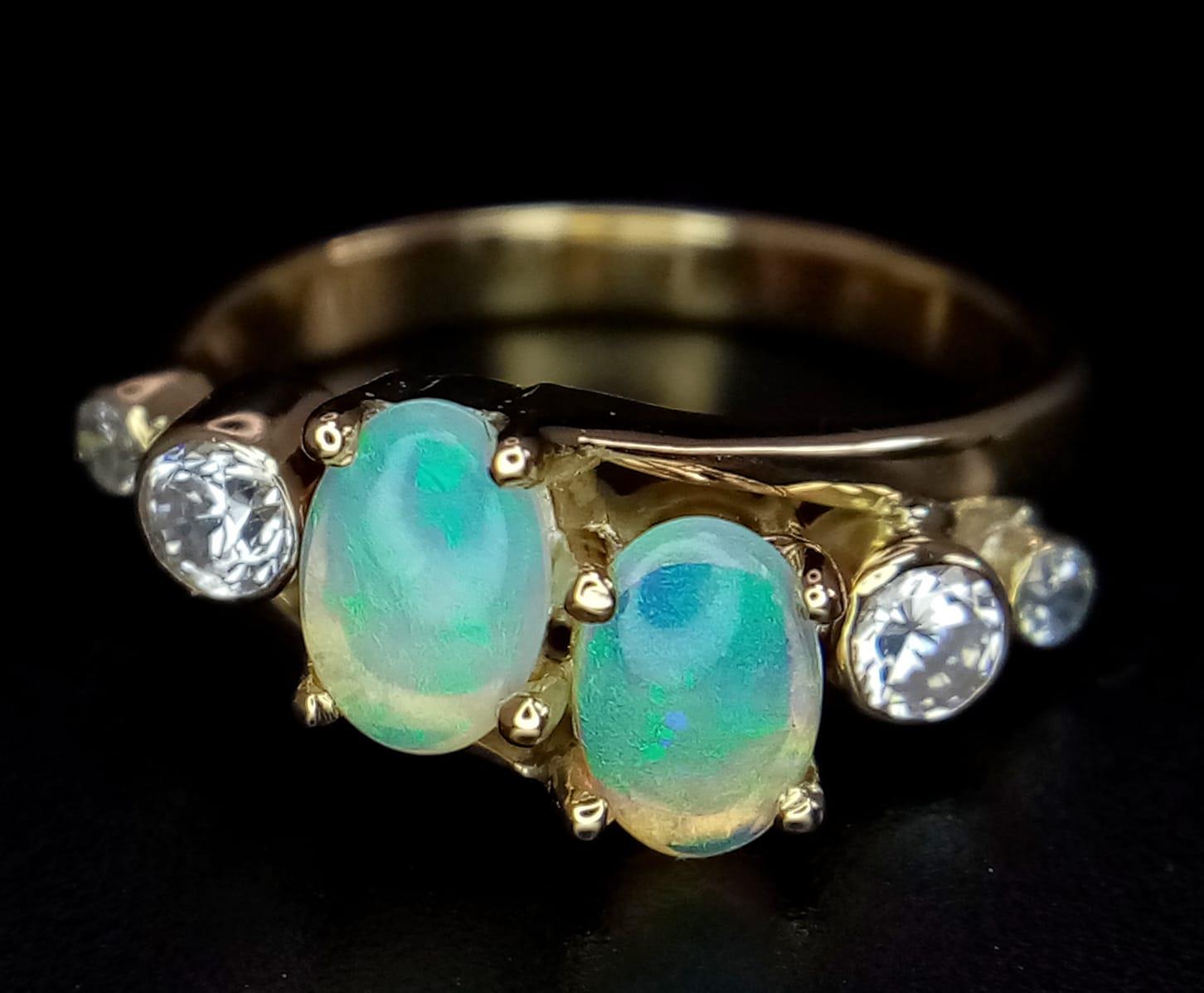 A STYLISH 18K YELLOW GOLD OPAL SET CROSSOVER RING, SET WITH 2 OPALS CENTRE AND FLANKED BY 2 CZ