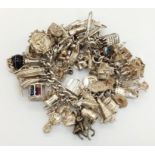 An Exceptional Hallmarked 1965 Silver Charms Bracelet with 60 charms of various types, many very