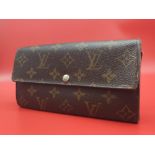 Louis Vuitton Wallet. Measuring 18.5cm wide, this Louis Vuitton wallet is patterned in the trademark