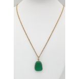 A 50cms 9K GOLD CHAIN WITH A JADE PENDANT . 8.6gms