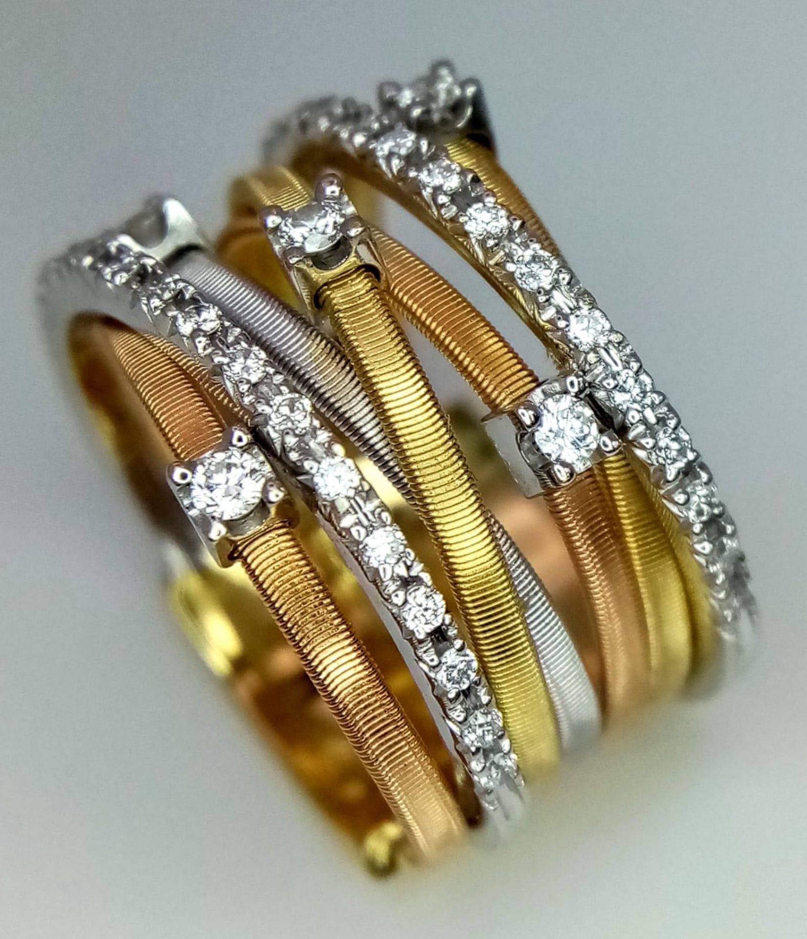 An Italian 18K Yellow and White Gold Diamond Orbital Ring. Front band of gold interspersed with