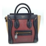 A Celine Burgundy and Khaki Handbag. Crafted from a smooth burgundy leather and features a black