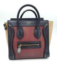A Celine Burgundy and Khaki Handbag. Crafted from a smooth burgundy leather and features a black
