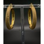 A PAIR OF 9K GOLD LARGE HOOP EARRINGS WITH ONE PLAIN SIDE AND THE OTHER BEING PATTERNED . 6.8gms