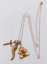 A 9 K yellow gold chain necklace with three charms, a teddy bear, a cornucopia (symbol of plenty)