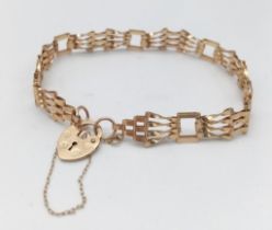 A VERY PRETTY DESIGNER VINTAGE 9K GOLD GATE BRACELET WITH HEART PADLOCK AND SAFETY CHAIN . 4.5gms