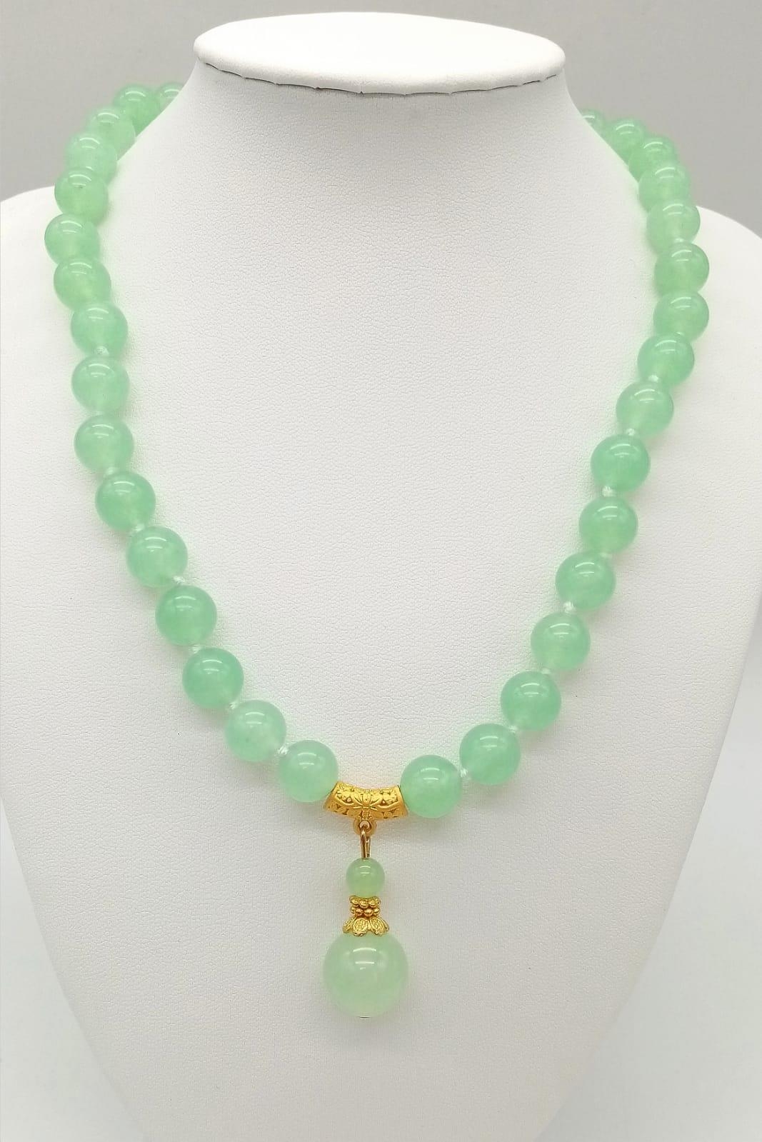 A Green Jade Bead Necklace with Hanging Green Jade Pendant. Gilded accents and clasp. 10mm beads. - Image 2 of 4