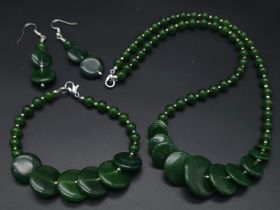 An unusual green jade disc necklace, bracelet and earrings set in a quality presentation box.