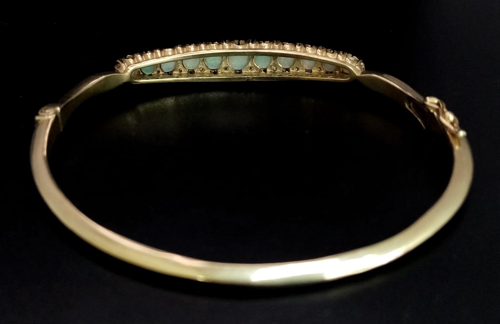 A Beautifully Made 9K Yellow Gold, Opal and Diamond Hinged Bracelet. Eleven opal graduating - Image 4 of 5