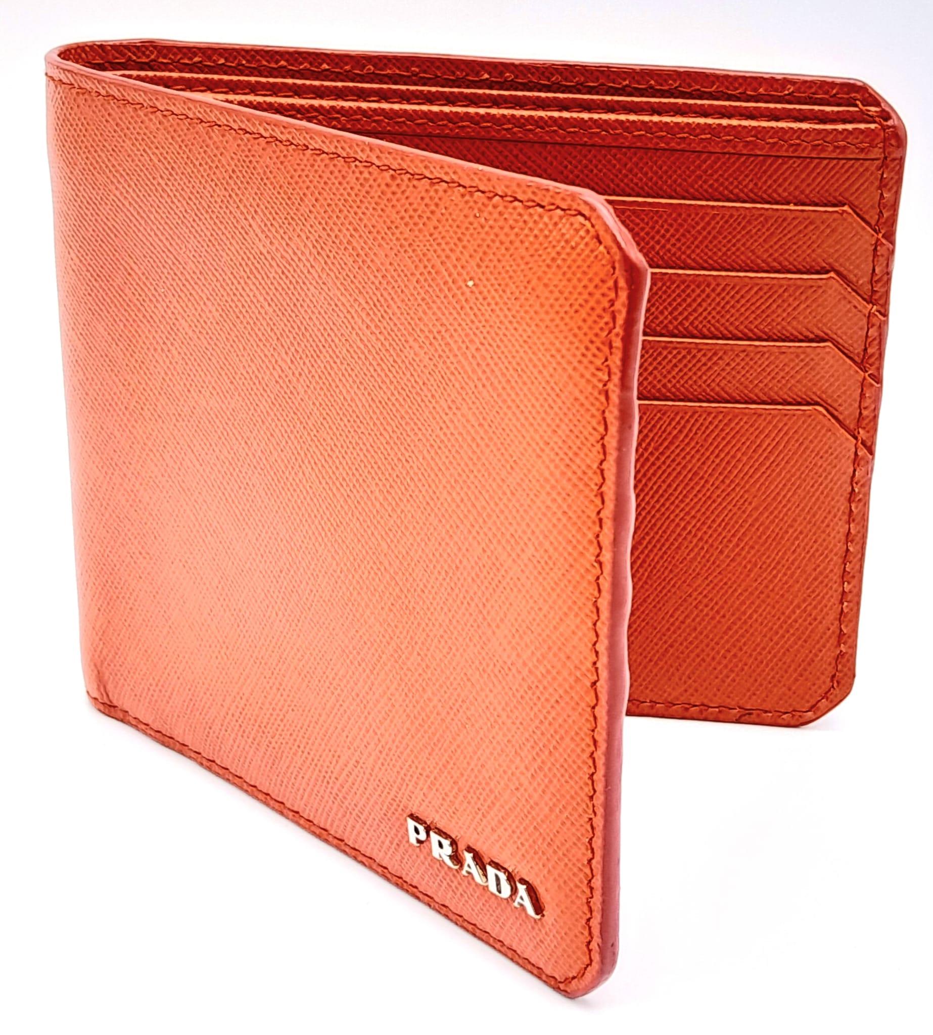 A Prada Burnt Orange Wallet. Leather exterior and interior, with silver-toned logo hardware. Two - Image 2 of 6