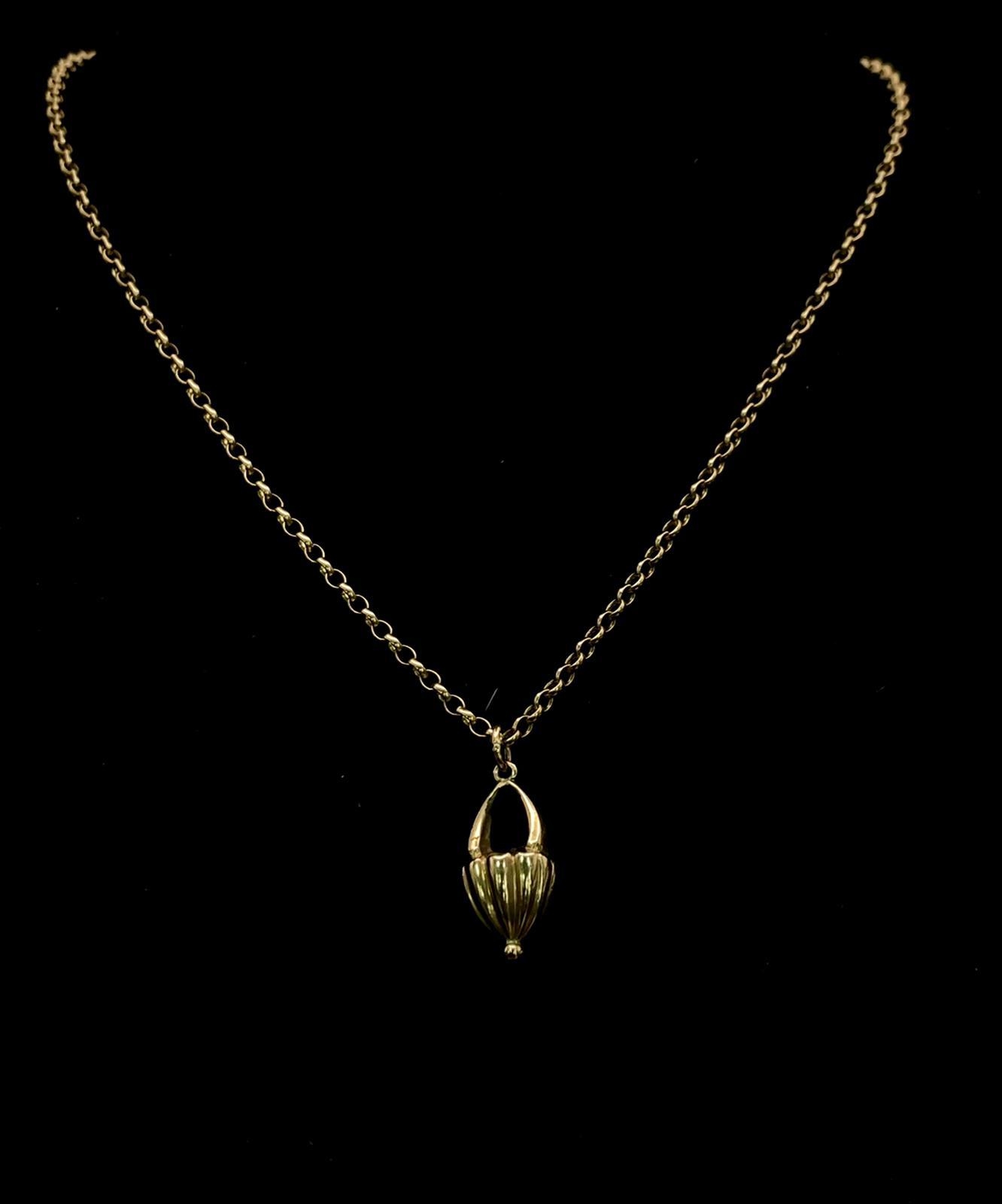 An Antique 9K Yellow Gold Floral Basket Pendant on a 9K Yellow Gold Small Belcher Link Necklace.