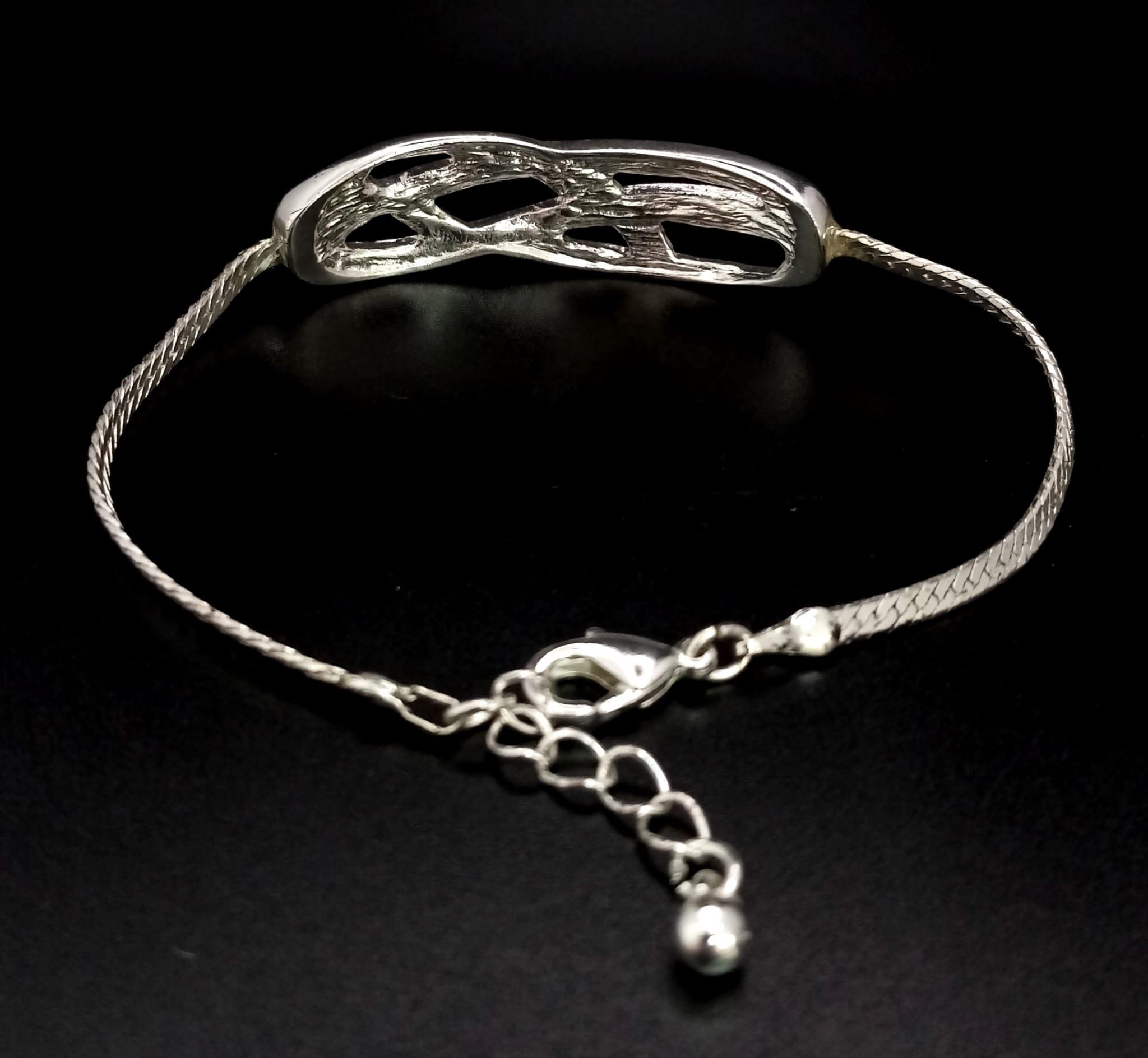 A very elegant, sterling silver bracelet with an eternity knot studded with clear stones. Weight: - Image 2 of 3