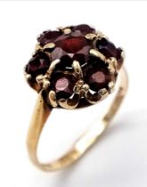 A 9K YELLOW GOLD GARNET CLUSTER RING. Size P, 3g total weight.