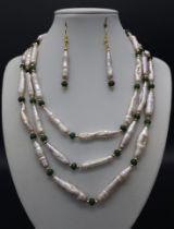 A statement necklace with three strands of top quality, large Biwa pink pearls and emeralds with a