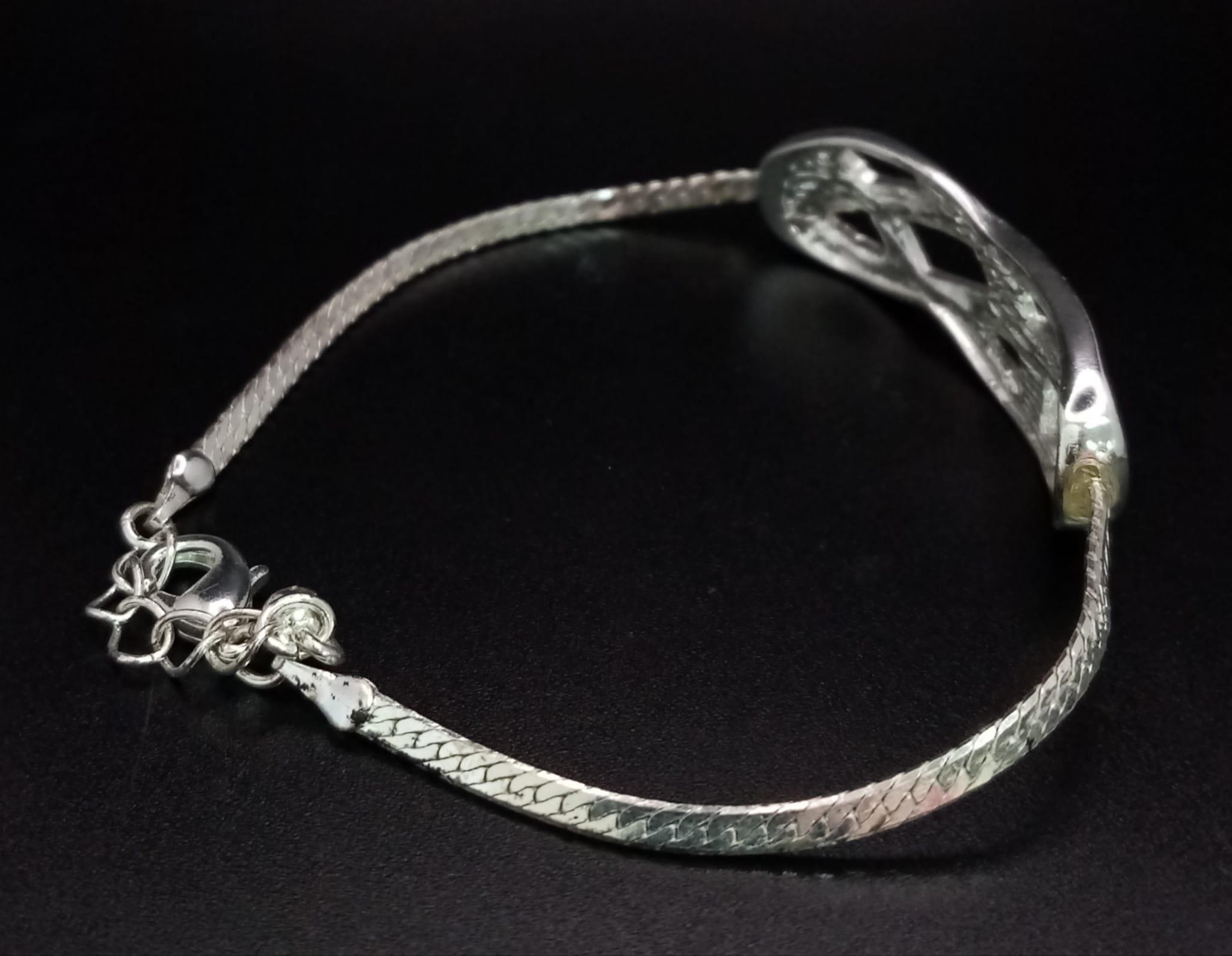 A very elegant, sterling silver bracelet with an eternity knot studded with clear stones. Weight: - Image 3 of 3