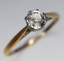 An 18 K yellow and white gold diamond solitaire ring, with the round cut diamond sitting proud on an
