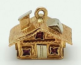 A 9K White and Yellow Gold House Pendant/Charm with Pink Topaz Decoration. 15mm. 4.53g weight.