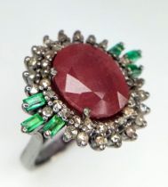 A Ruby Ring with Diamond Surround and Baguette Cut Emerald Accents, on 925 Silver. Ring size L. 5.