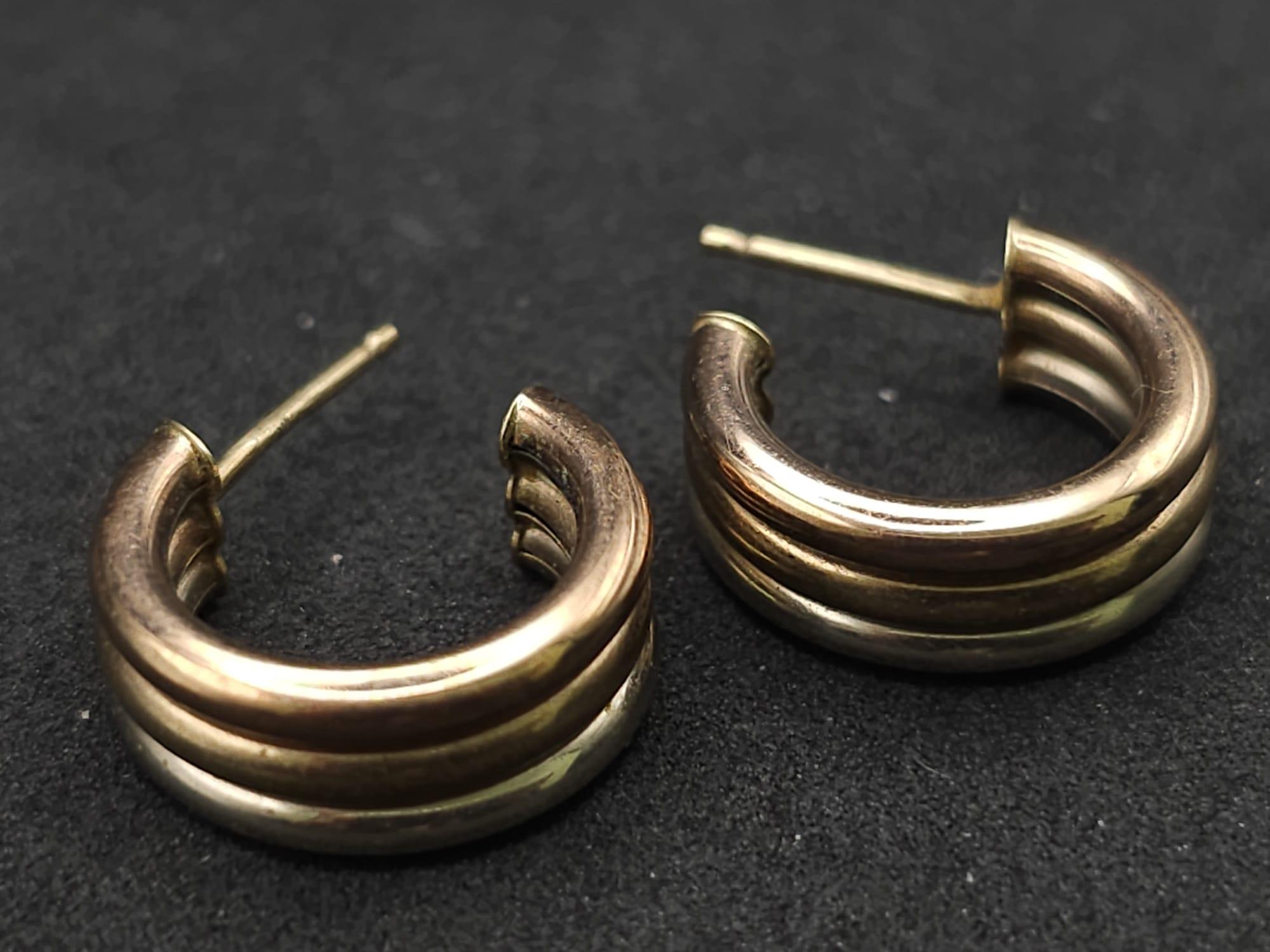 A 9 K three coloured gold pair of earrings . Dimensions: 16 x 13 x 6 mm, weight: 1.7 g.