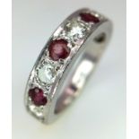 An 18K White Gold Ruby and Diamond Half Eternity Ring. Nine gemstones. Size K. 5.89g total weight.