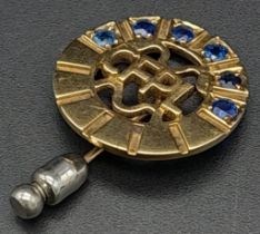 A Vintage 9K Yellow Gold and Sapphire Circular Pin Brooch. Six sapphires amongst pierced decoartion.