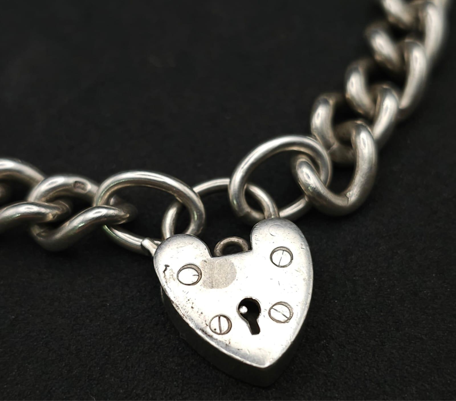 A Sterling silver chunky charm bracelet with heart padlock fastening. 31.6g - Image 2 of 7