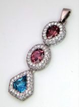 An 18K White Gold (tested) Ruby, Diamond and Topaz Drop Pendant. Three gemstones with diamond