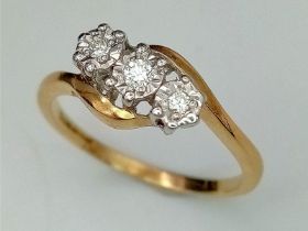 AN 18K YELLOW GOLD DIAMOND 3 STONE TWIST RING. Size R, 2.6g total weight.