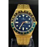 An Unworn Q Timex Reissue Gold Tone Watch. 38mm Stainless Steel Case. Blue & Black Bezel (The