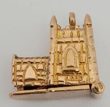 A 9K Yellow Gold Castle Pendant/Charm which opens to reveal a couple in ceremony, 20mm. 4.89g
