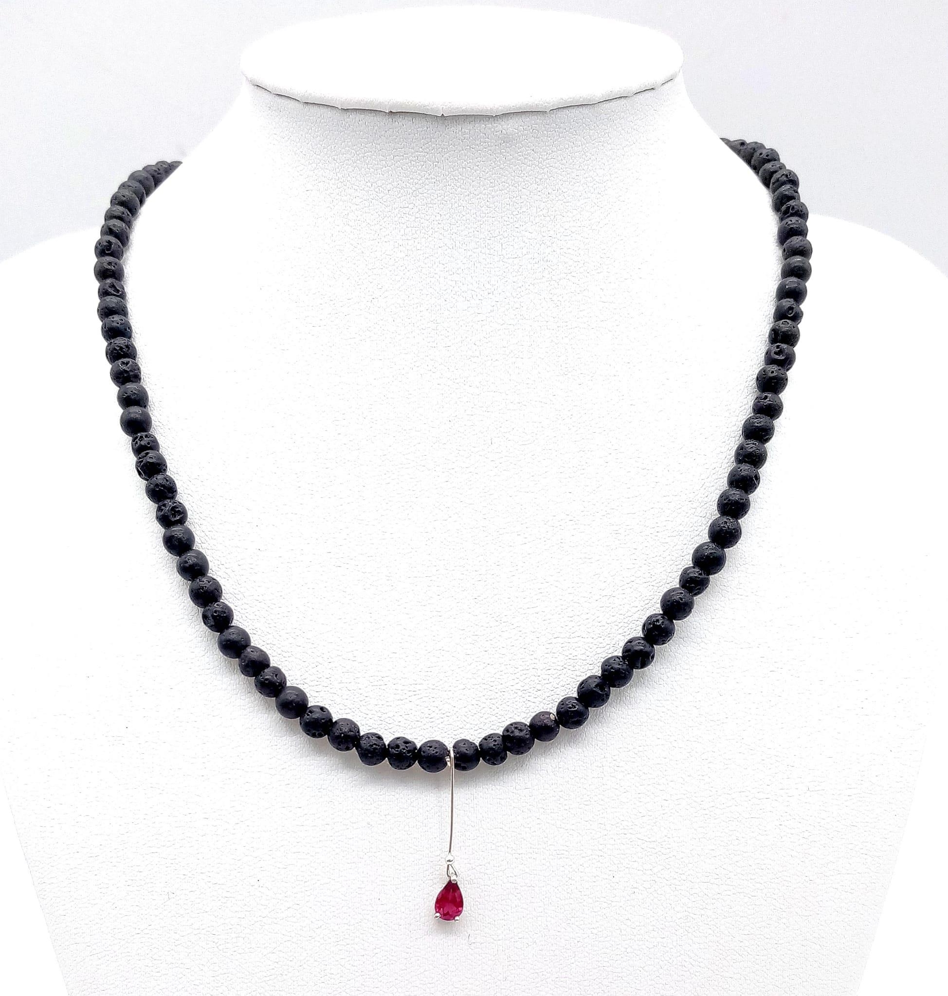 AN UNUSUAL 40cms BEADED NECKLACE MADE FROM VOLCANIC LAVA WITH A SMALL AMETHYST PENDANT . 12.2gms