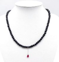AN UNUSUAL 40cms BEADED NECKLACE MADE FROM VOLCANIC LAVA WITH A SMALL AMETHYST PENDANT . 12.2gms