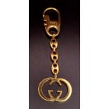 A Gucci Gold Plated Interlocking Keychain. This well constructed Gucci logo keychain is 12cm in