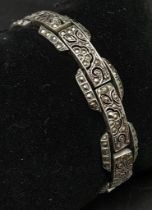 A vintage, sterling silver bracelet, with an elaborate filigree design studded with marcasite.
